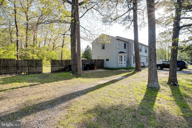 view of home's exterior with fence and a yard