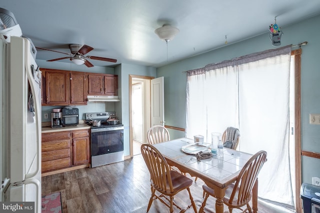 kitchen featuring brown cabinets, stainless steel range with electric cooktop, freestanding refrigerator, wood finished floors, and under cabinet range hood