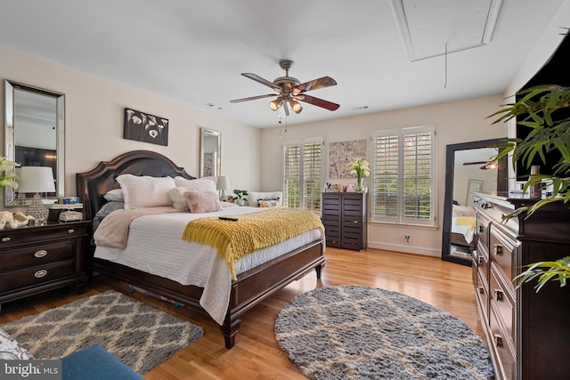 bedroom featuring attic access, baseboards, and wood finished floors