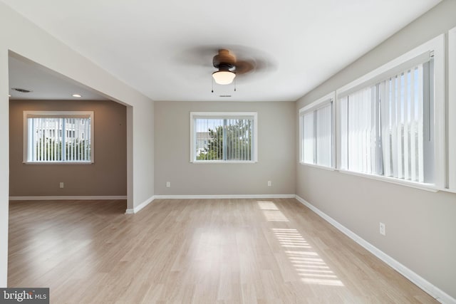 unfurnished room featuring light wood-type flooring, baseboards, and a ceiling fan