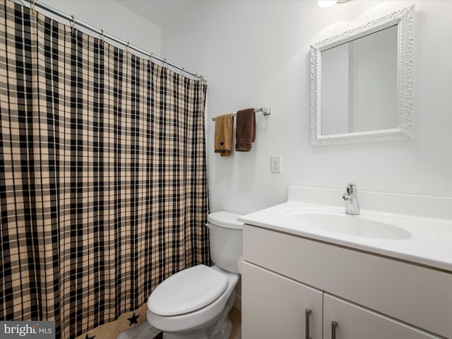 bathroom with toilet, vanity, and curtained shower