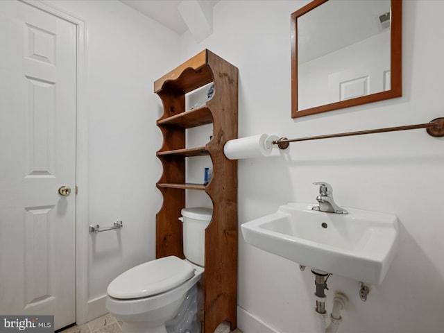 half bath featuring visible vents, baseboards, and toilet