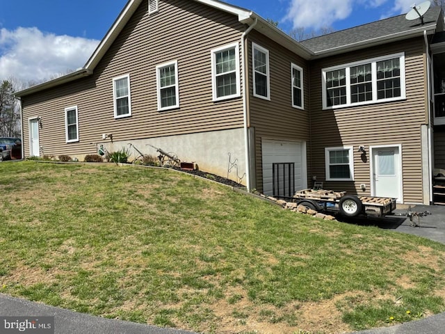 view of property exterior with a yard and a garage