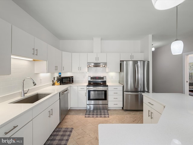 kitchen featuring decorative backsplash, light countertops, a sink, and appliances with stainless steel finishes