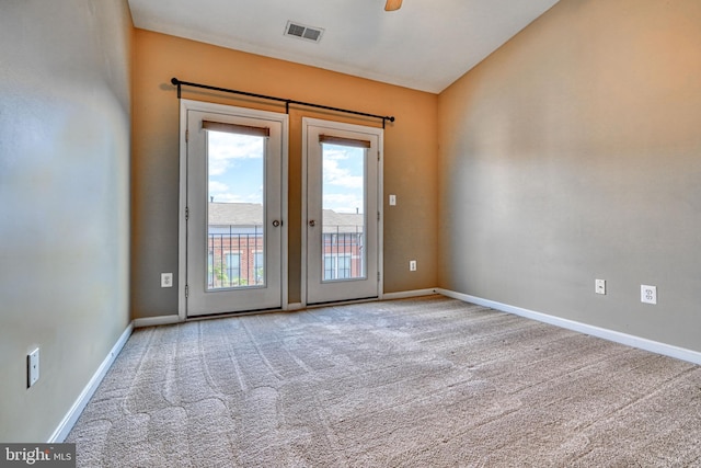 doorway to outside featuring visible vents, lofted ceiling, baseboards, ceiling fan, and carpet