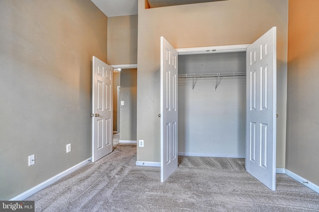 unfurnished bedroom featuring baseboards, carpet, and a closet