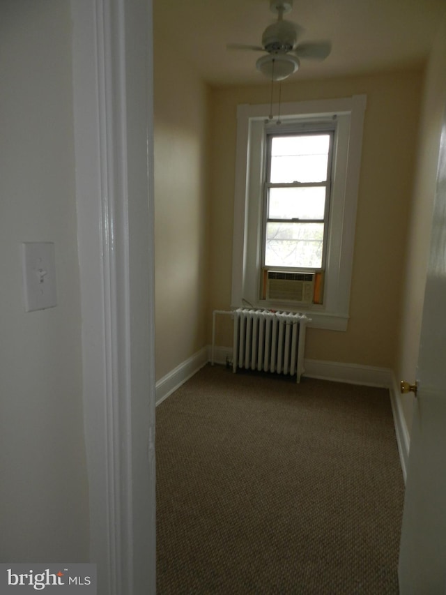 carpeted empty room with radiator heating unit, cooling unit, ceiling fan, and baseboards