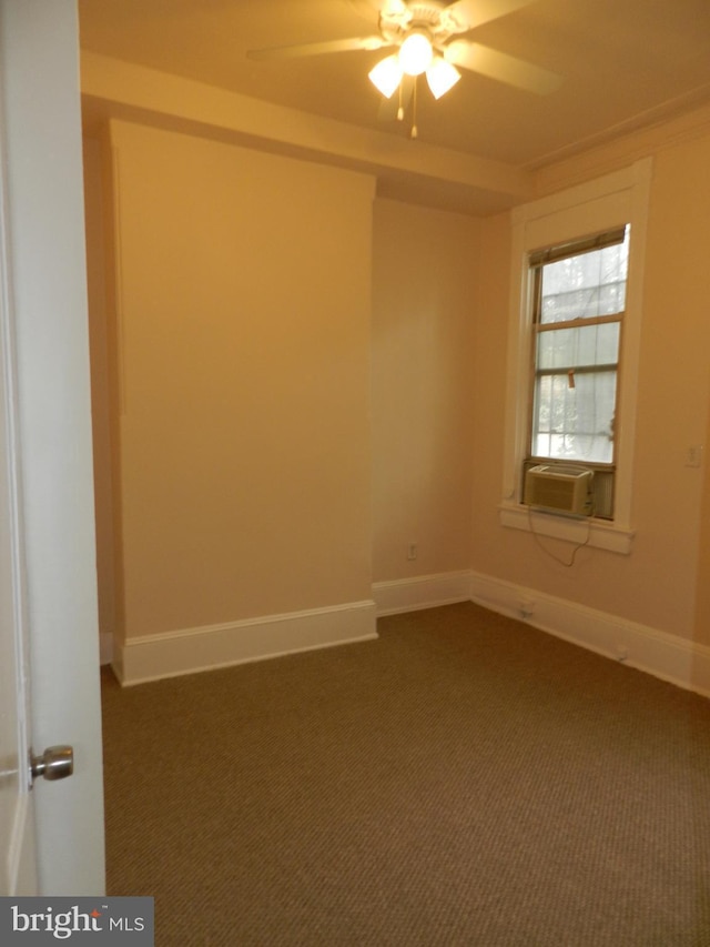 empty room featuring dark carpet, baseboards, and a ceiling fan