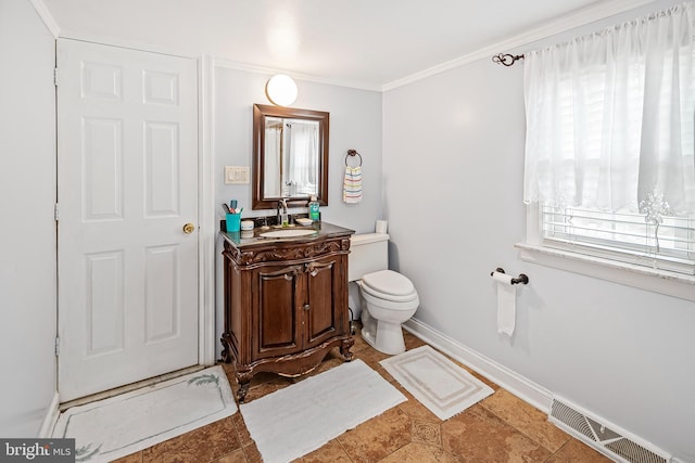 bathroom featuring visible vents, baseboards, ornamental molding, toilet, and vanity