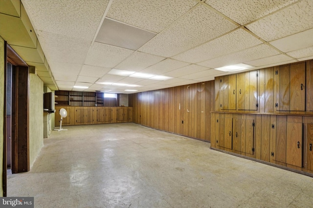 finished below grade area featuring wood walls and a drop ceiling