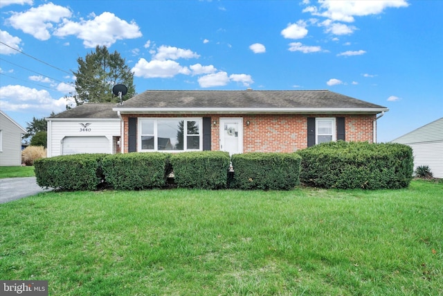 ranch-style home with roof with shingles, brick siding, an attached garage, and a front lawn