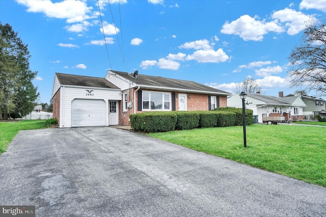 ranch-style home featuring aphalt driveway, a garage, a front lawn, and brick siding