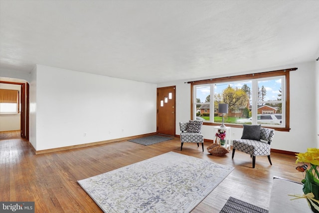 living area with baseboards and wood finished floors