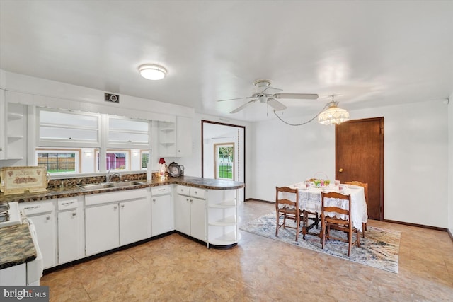 kitchen featuring a ceiling fan, white cabinetry, open shelves, a sink, and dark countertops