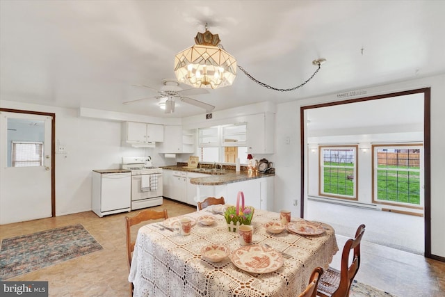 dining room with plenty of natural light, ceiling fan with notable chandelier, and baseboards
