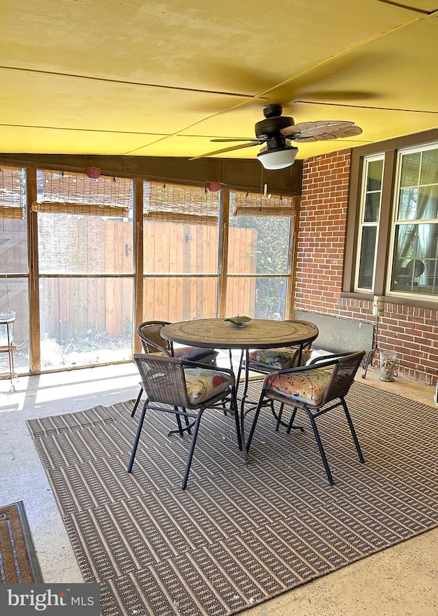 sunroom with outdoor dining space and ceiling fan