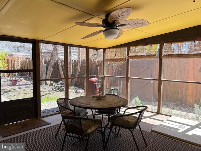 sunroom / solarium with a ceiling fan and outdoor dining area