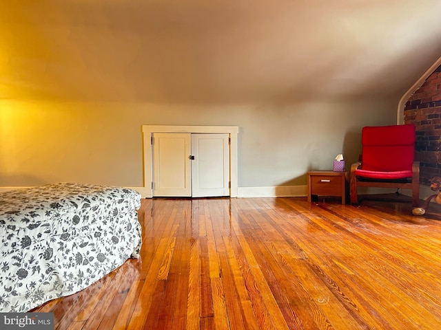 bedroom with hardwood / wood-style flooring and baseboards