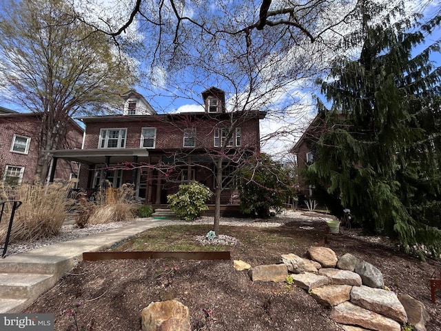view of front of house featuring a porch and brick siding