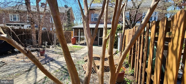 view of yard featuring a fenced backyard and a sunroom