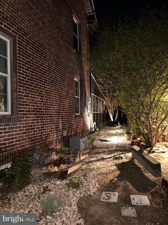 view of property exterior featuring brick siding and central AC unit
