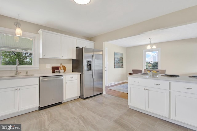 22 Spring Ridge Dr, York, PA 17408 - kitchen featuring white cabinetry, appliances with stainless steel finishes, light countertops, a sink, and decorative light fixtures