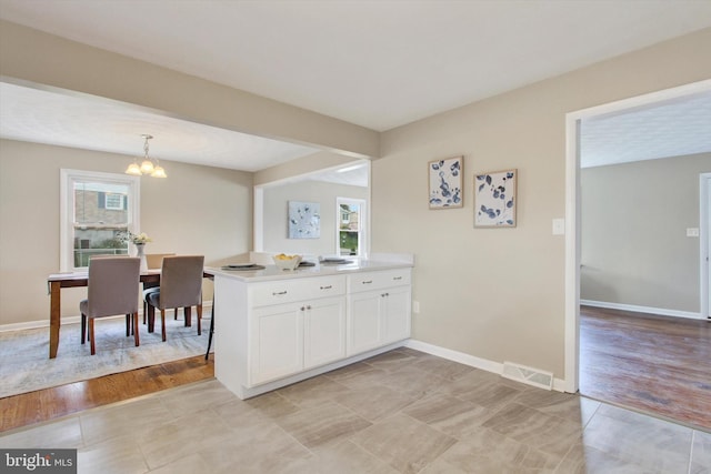 22 Spring Ridge Dr, York, PA 17408 - kitchen featuring light tile patterned floors, white cabinets, a notable chandelier, and a wealth of natural light