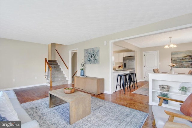 22 Spring Ridge Dr, York, PA 17408 - living area with wood finished floors, a notable chandelier, baseboards, and stairway