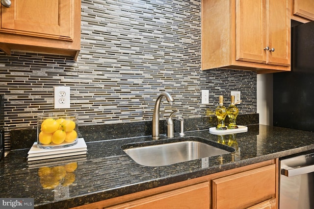 kitchen featuring tasteful backsplash, a sink, and dark stone counters