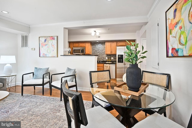 dining area with ornamental molding, visible vents, recessed lighting, and light wood-style floors