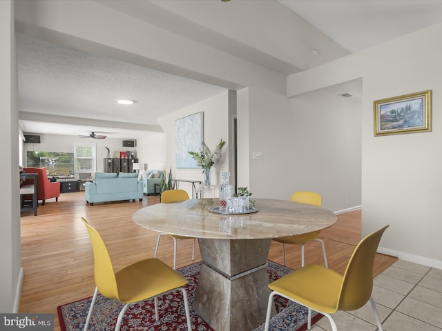 dining space with a ceiling fan, baseboards, and light wood-type flooring