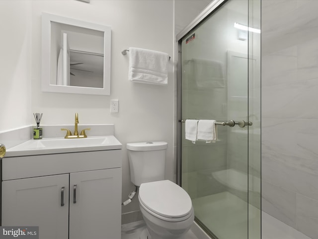 full bathroom featuring a stall shower, toilet, and vanity