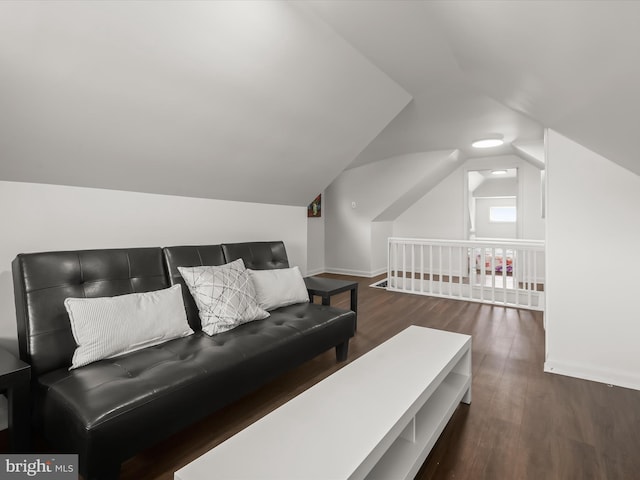 living area featuring lofted ceiling, wood finished floors, and baseboards