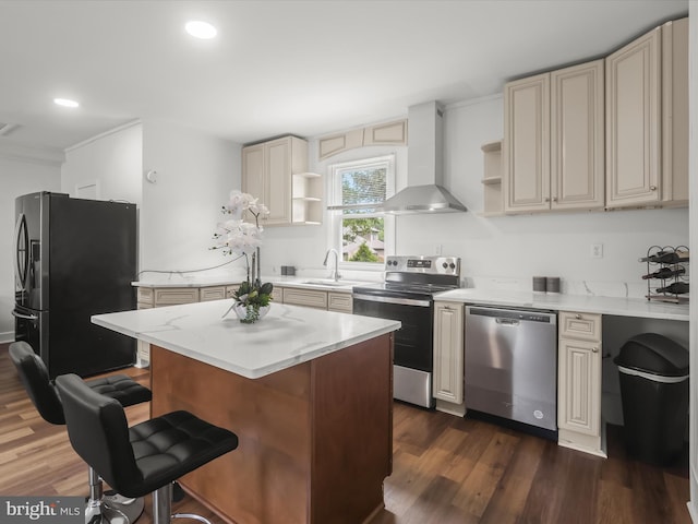 kitchen featuring appliances with stainless steel finishes, wall chimney exhaust hood, open shelves, cream cabinets, and recessed lighting