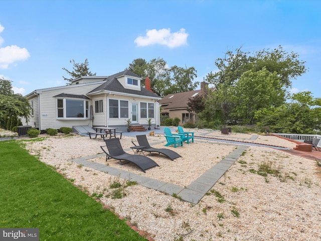 back of house featuring a patio, entry steps, an outdoor fire pit, and cooling unit
