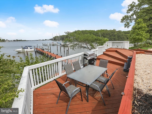 deck with a grill, a water view, a dock, outdoor dining space, and boat lift