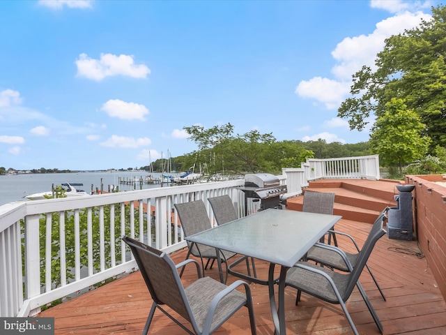 deck with a grill, a water view, and outdoor dining space