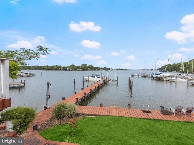 dock featuring a water view, boat lift, and a yard