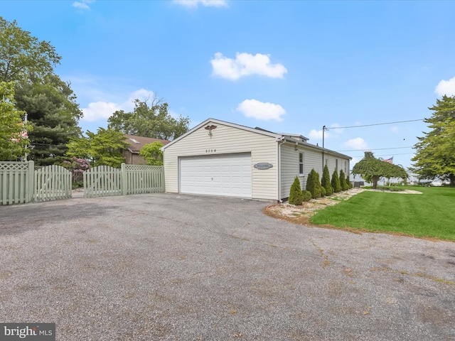 garage with asphalt driveway and a gate