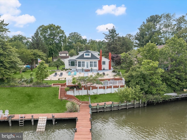 back of house featuring a yard, stairs, a patio area, a chimney, and a deck with water view