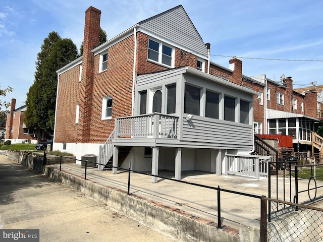 4301 Brehms Ln, Baltimore, MD 21206 - back of house featuring stairs, a chimney, brick siding, and fence