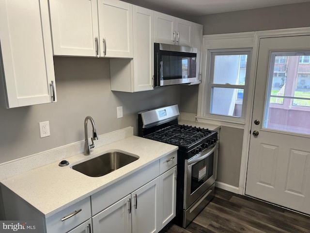 4301 Brehms Ln, Baltimore, MD 21206 - kitchen featuring stainless steel appliances, a sink, white cabinetry, and dark wood-style flooring