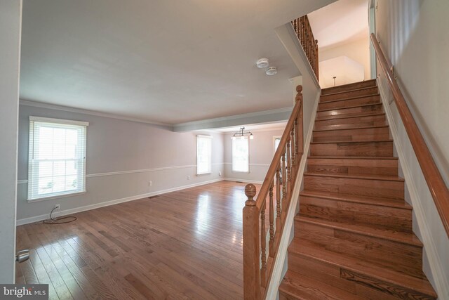 312 Fairgrove Ter, Gaithersburg, MD 20877 - staircase featuring healthy amount of natural light, crown molding, hardwood / wood-style flooring, and a chandelier