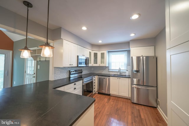 312 Fairgrove Ter, Gaithersburg, MD 20877 - kitchen with stainless steel appliances, dark countertops, backsplash, hardwood / wood-style floors, and glass insert cabinets