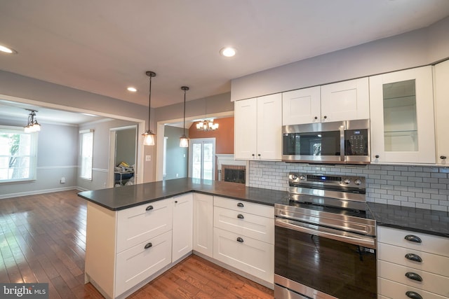 312 Fairgrove Ter, Gaithersburg, MD 20877 - kitchen with stainless steel appliances, a peninsula, a chandelier, dark countertops, and wood finished floors