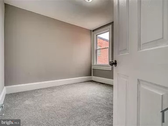 empty room featuring baseboards and carpet