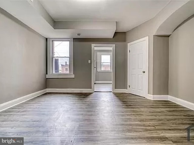spare room featuring wood finished floors and baseboards