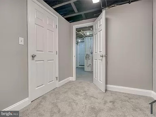 finished basement featuring baseboards and light carpet