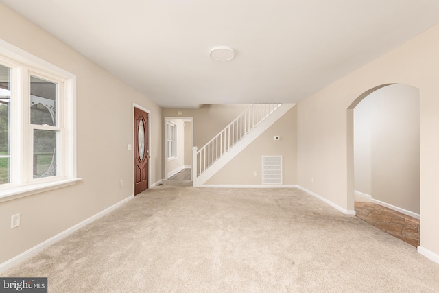 4808 Frazier Neck Rd, Preston, MD 21655 - unfurnished living room with carpet flooring, arched walkways, visible vents, baseboards, and stairway