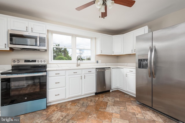 4808 Frazier Neck Rd, Preston, MD 21655 - kitchen featuring a sink, white cabinetry, stone finish floor, light countertops, and appliances with stainless steel finishes